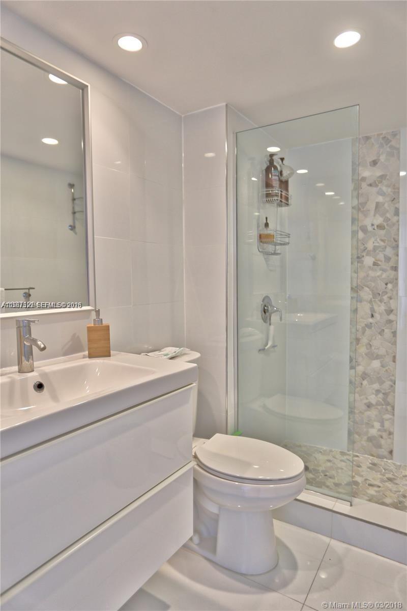 5555 Collins Avenue, Unit 5F Miami Beach, FL 33140 - Photo 4 of 6 a bathroom with a toilet a sink and shower
