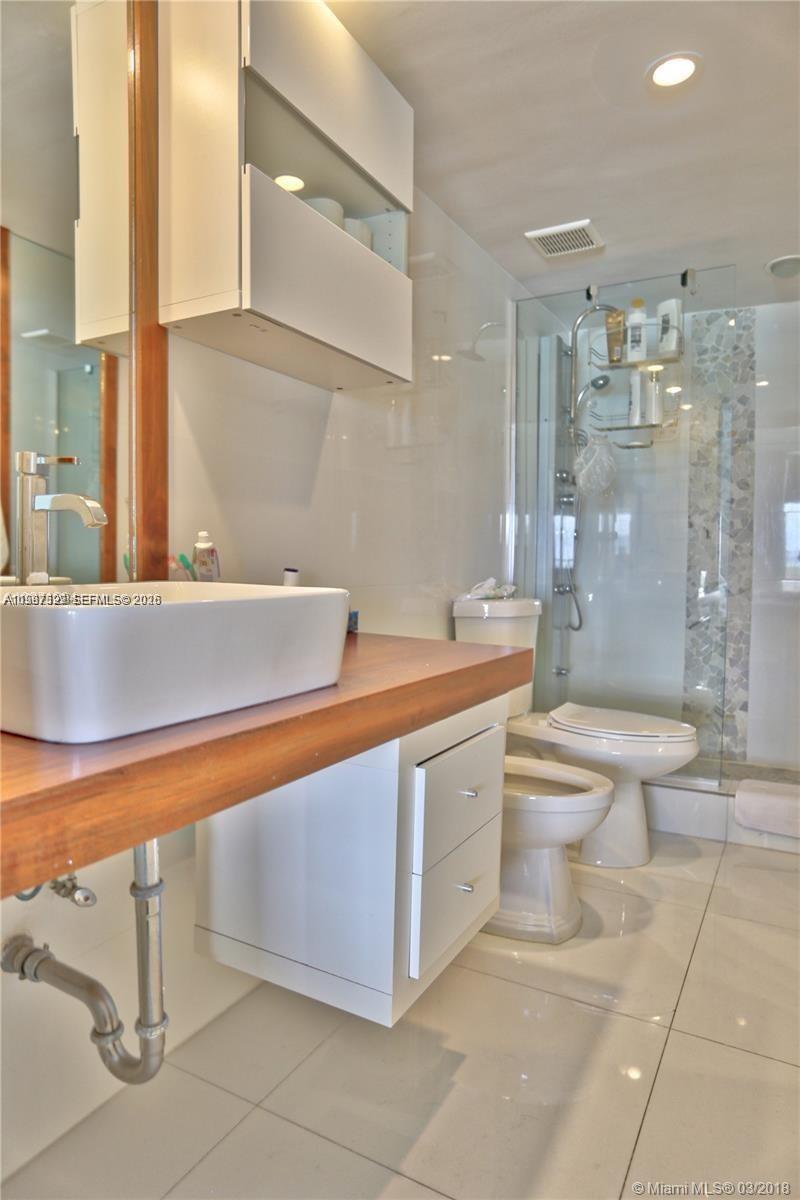 5555 Collins Avenue, Unit 5F Miami Beach, FL 33140 - Photo 5 of 6 a bathroom with a sink a toilet and shower