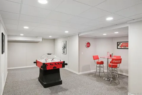 a living room with furniture a flat screen tv and gym equipment