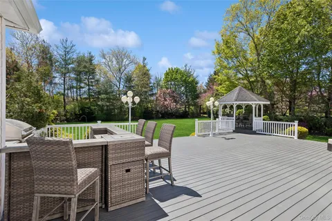 a view of a patio with a table chairs and a yard