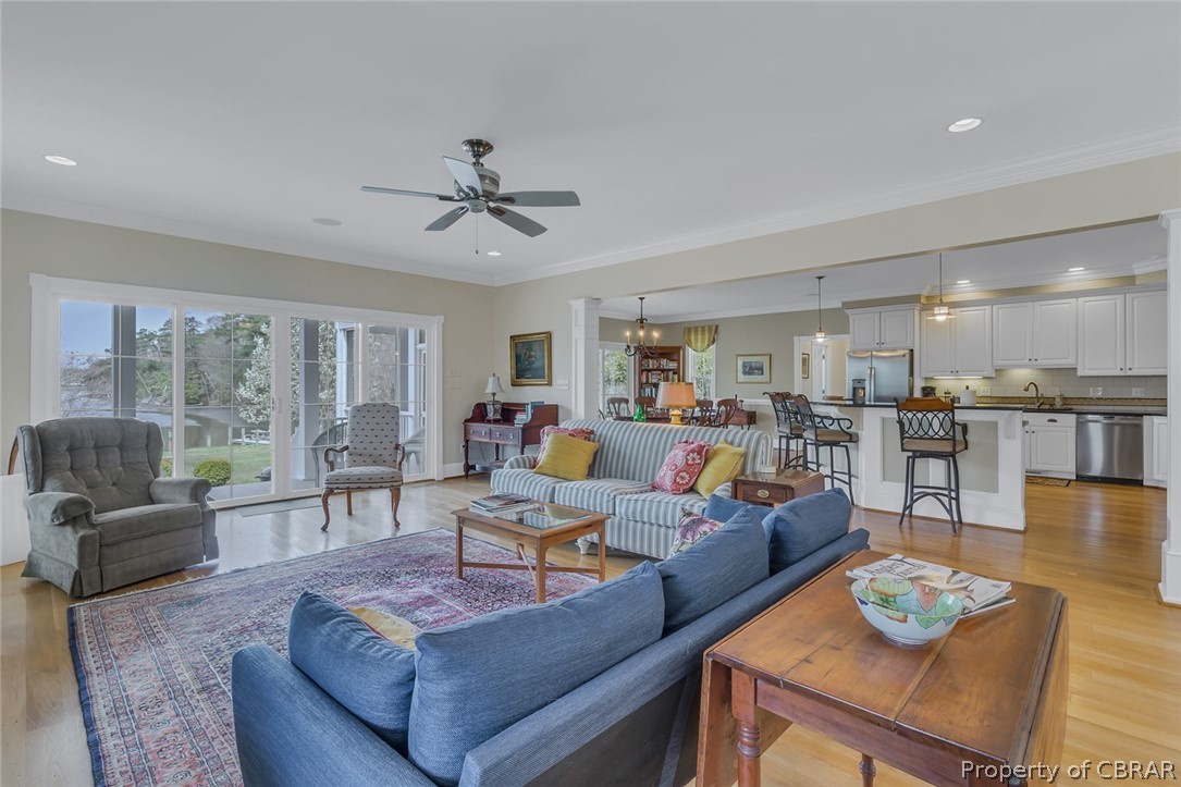 507 Sunnybank Road Reedville, VA 22539 - Photo 21 of 48 Living room with ceiling fan with notable chandelier, crown molding, and light wood-type flooring