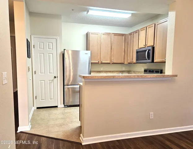 a kitchen with stainless steel appliances granite countertop a refrigerator and a stove