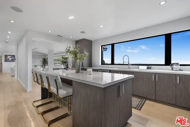 a kitchen with kitchen island a sink and a refrigerator