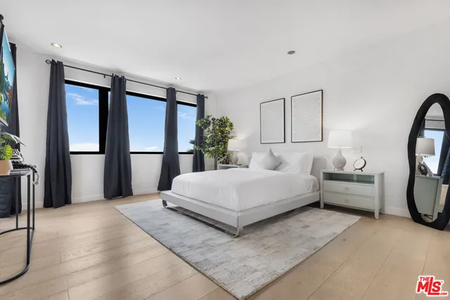 a spacious bedroom with a large bed and a large mirror