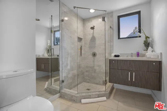 a bathroom with a shower sink mirror and toilet