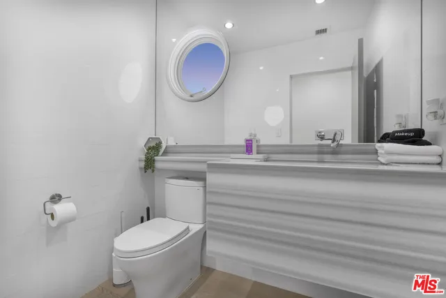 a bathroom with a sink a toilet and a mirror