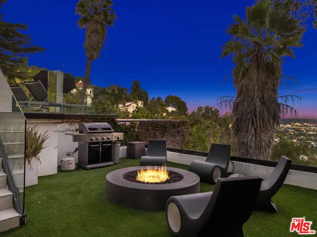 a view of a backyard with furniture and a fire pit