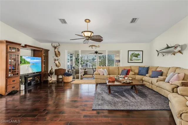 a living room with furniture kitchen view and a large window