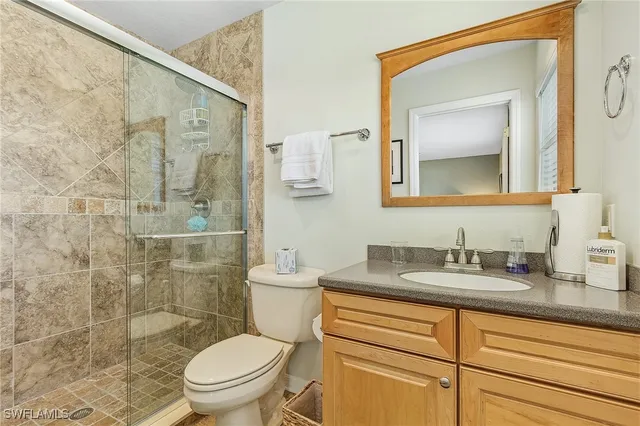 a bathroom with a granite countertop sink a toilet and a mirror