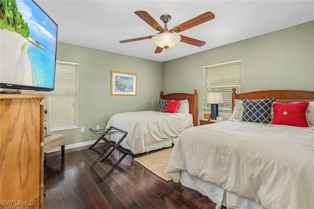 a bedroom with two beds and a lamp on the dresser