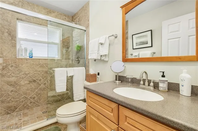 a bathroom with a granite countertop toilet sink and a mirror