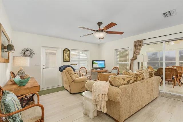 a living room with furniture ceiling fan and a large window