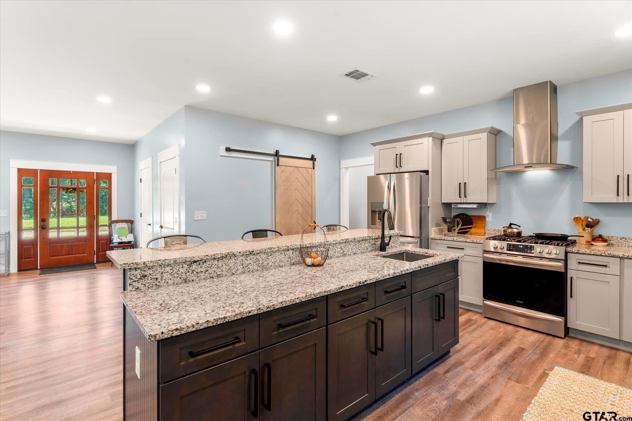 1663 County Road 4510 Pittsburg, TX 75686 - Photo 14 of 34 a kitchen with granite countertop kitchen island stainless steel appliances a sink stove top oven and cabinets