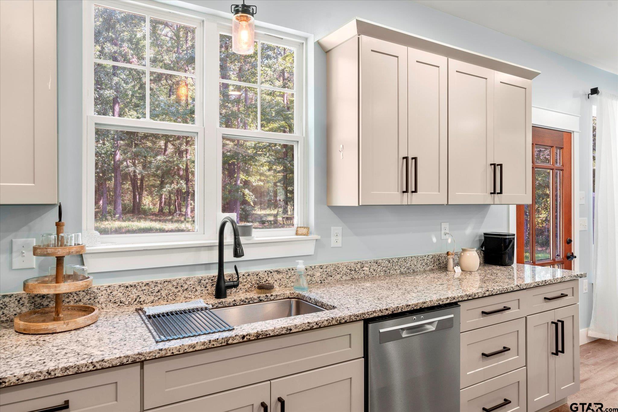 1663 County Road 4510 Pittsburg, TX 75686 - Photo 16 of 34 a kitchen with granite countertop white cabinets and window