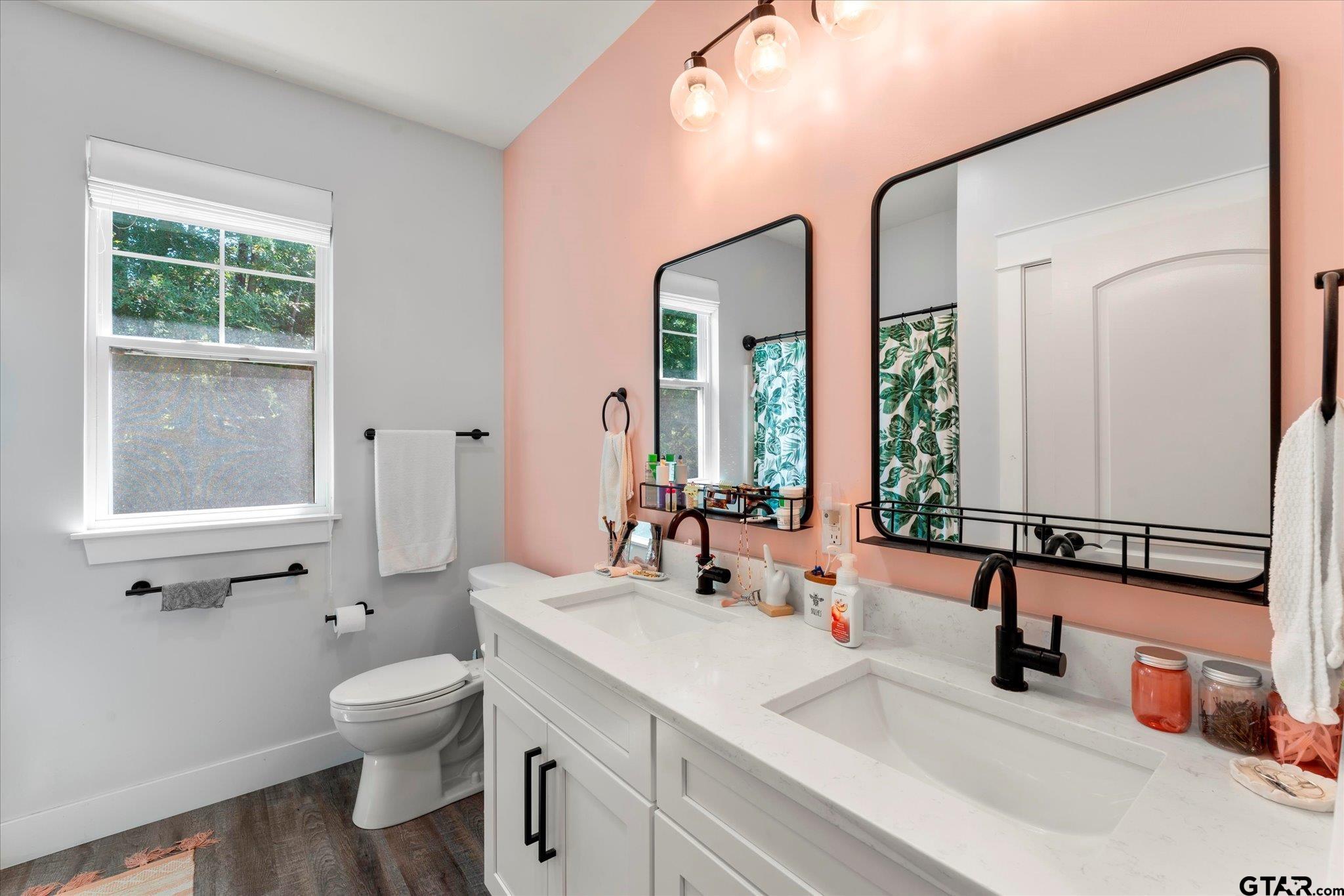 1663 County Road 4510 Pittsburg, TX 75686 - Photo 26 of 34 a bathroom with double vanity sink a mirror and a toilet