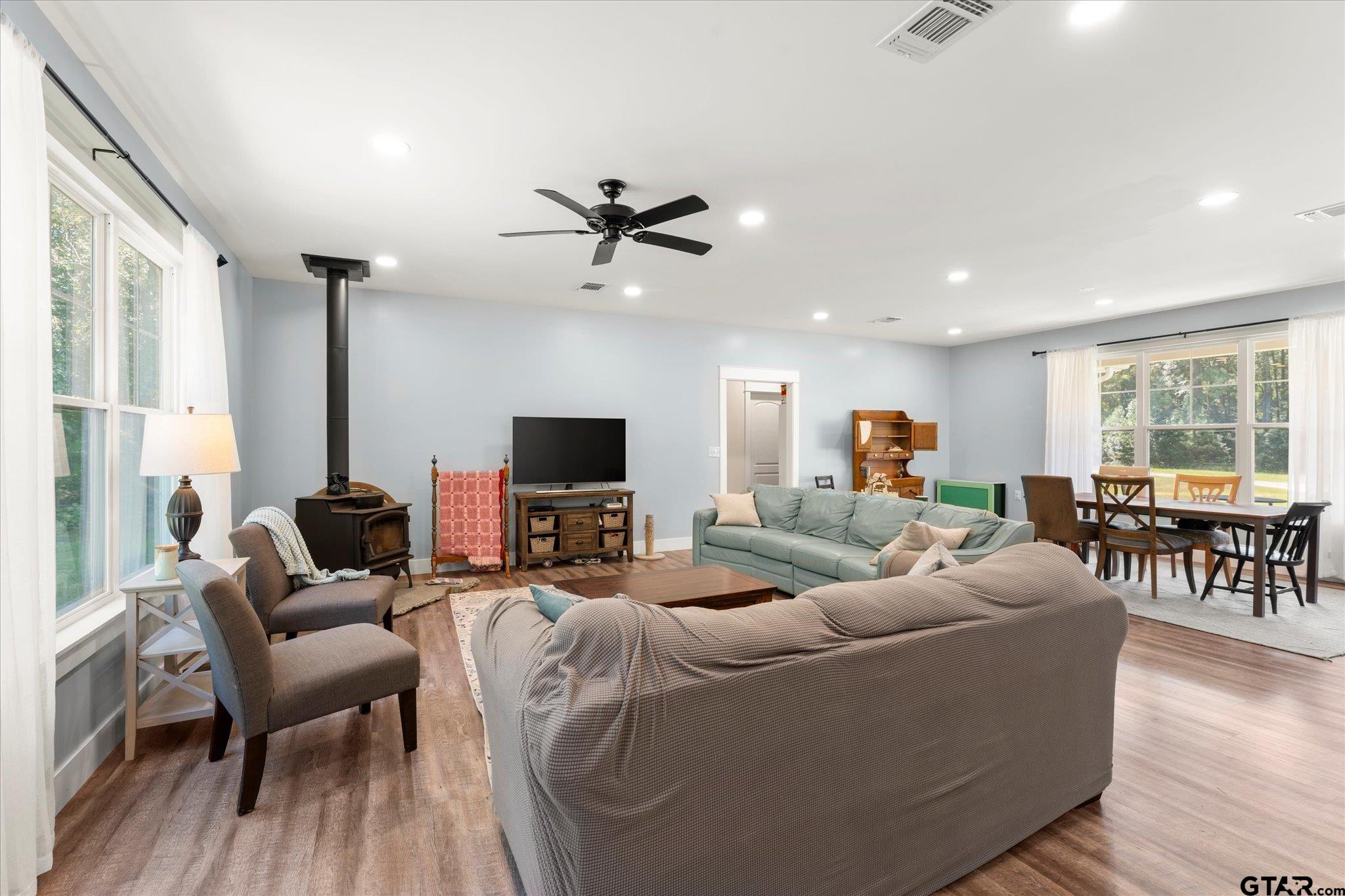 1663 County Road 4510 Pittsburg, TX 75686 - Photo 9 of 34 a living room with furniture a ceiling fan and a large window