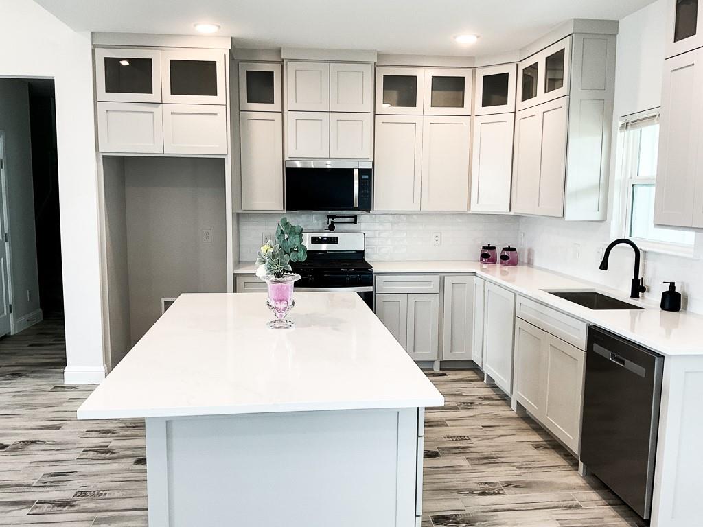 201 Bluff Court Godley, TX 76044 - Photo 7 of 17 a kitchen with kitchen island a sink stainless steel appliances and cabinets