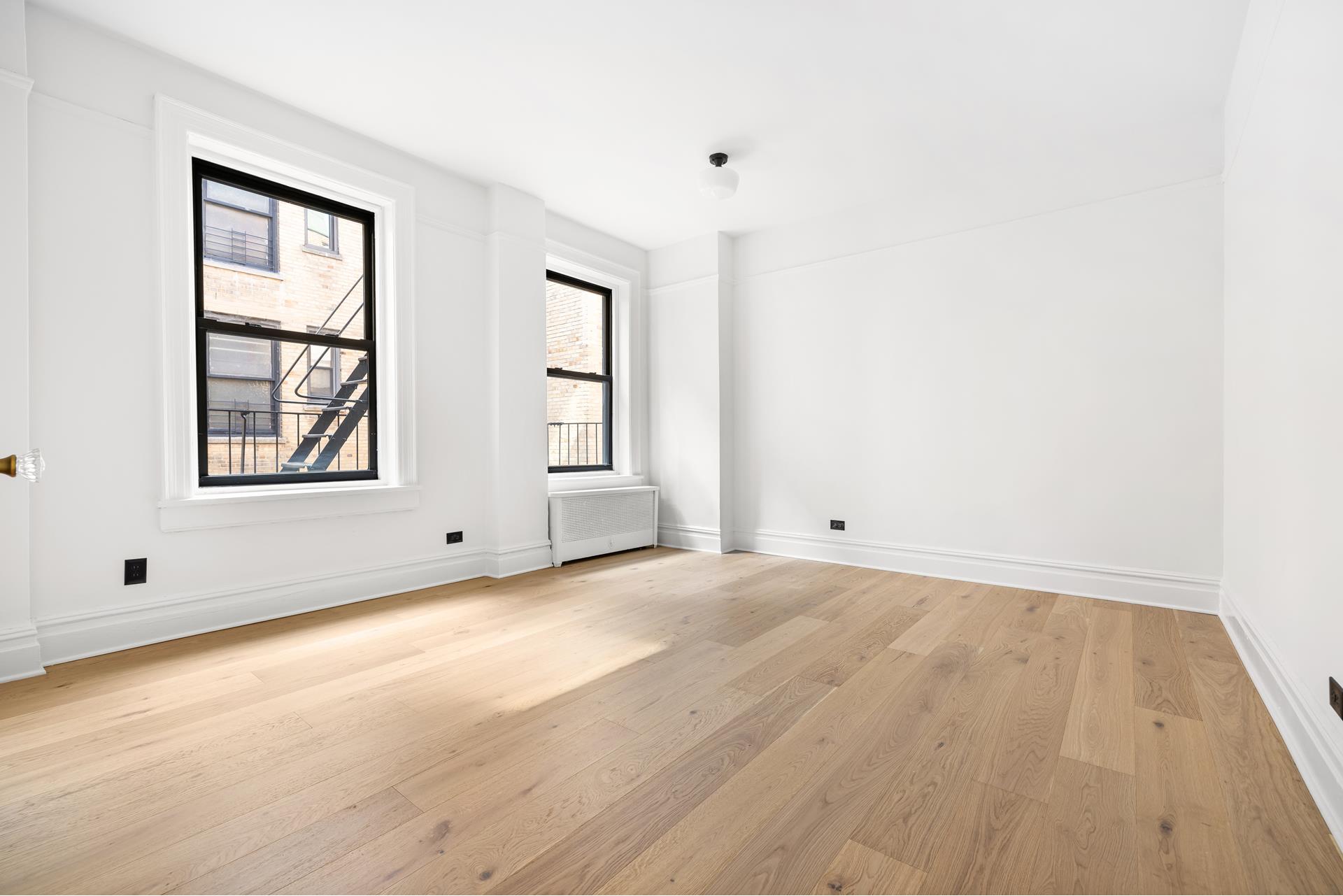 340 West 86th Street, Unit 11C Manhattan, NY 10024 - Photo 11 of 15 an empty room with wooden floor and windows