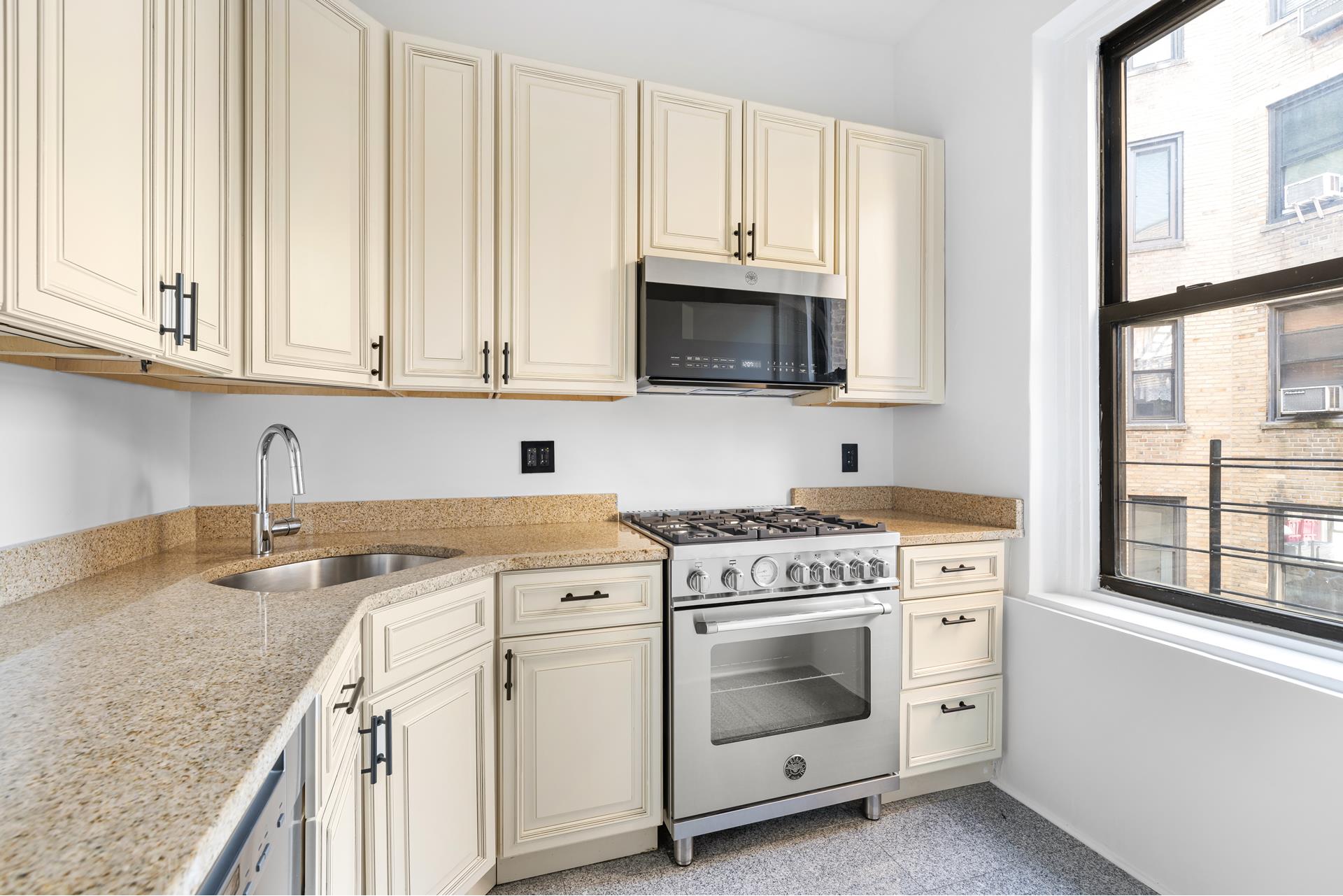340 West 86th Street, Unit 11C Manhattan, NY 10024 - Photo 5 of 15 a kitchen with granite countertop white cabinets and white stainless steel appliances
