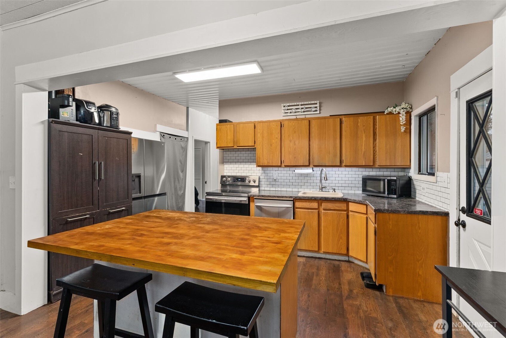 610 Barnhart Street Raymond, WA 98577 - Photo 14 of 34 a kitchen with stainless steel appliances granite countertop a kitchen island a stove a sink dishwasher and white cabinets with wooden floor