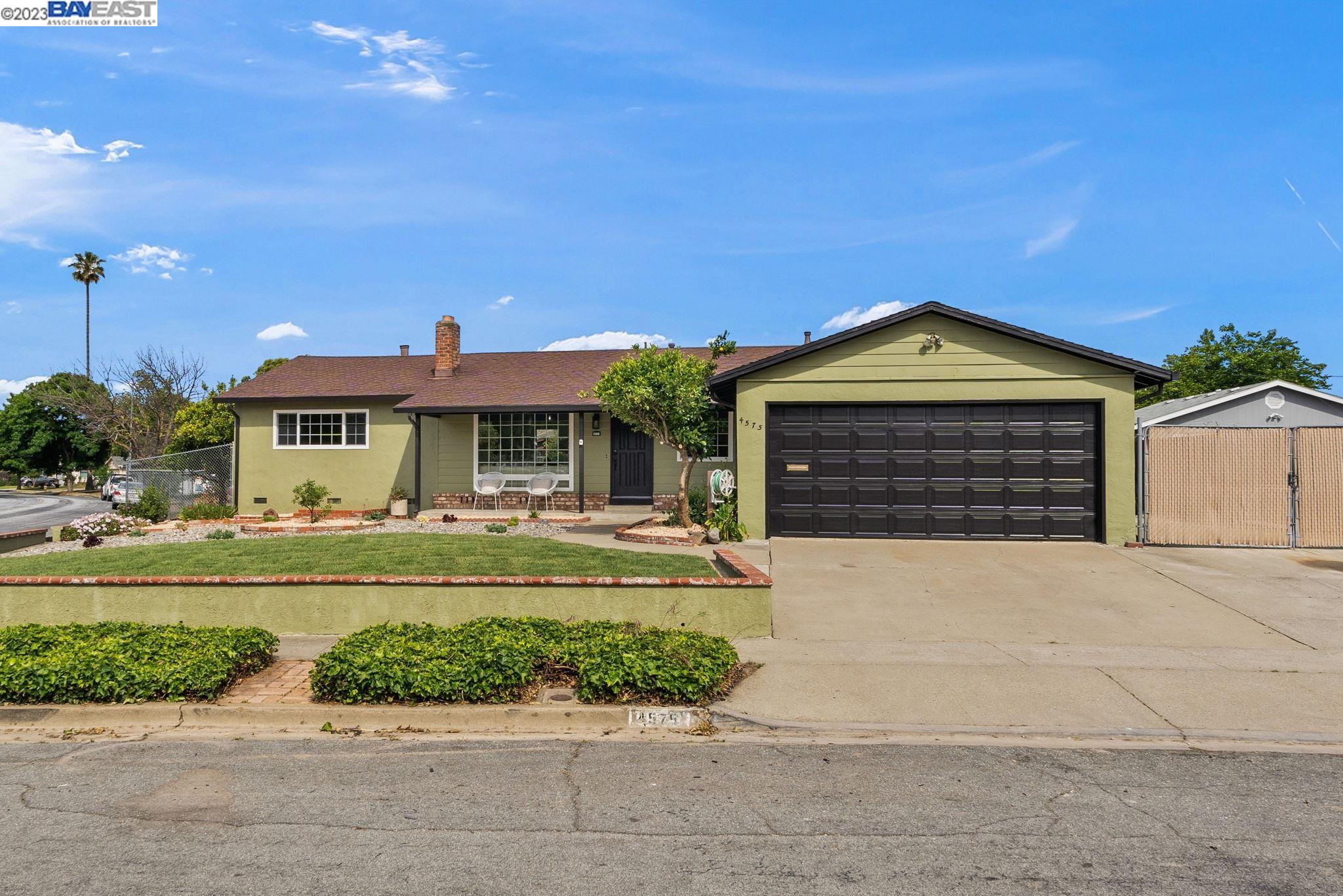 a front view of a house with a yard and potted plants