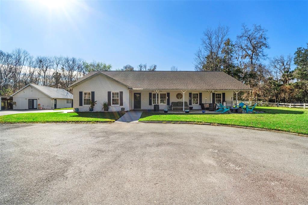 a view of a house with a big yard and large trees