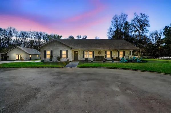 a front view of a house with a yard and trees
