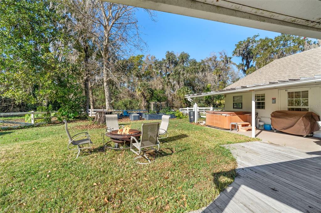 3080 Ragis Road Edgewater, FL 32132 - Photo 23 of 86 a view of a patio with table and chairs potted plants with wooden floor and fence