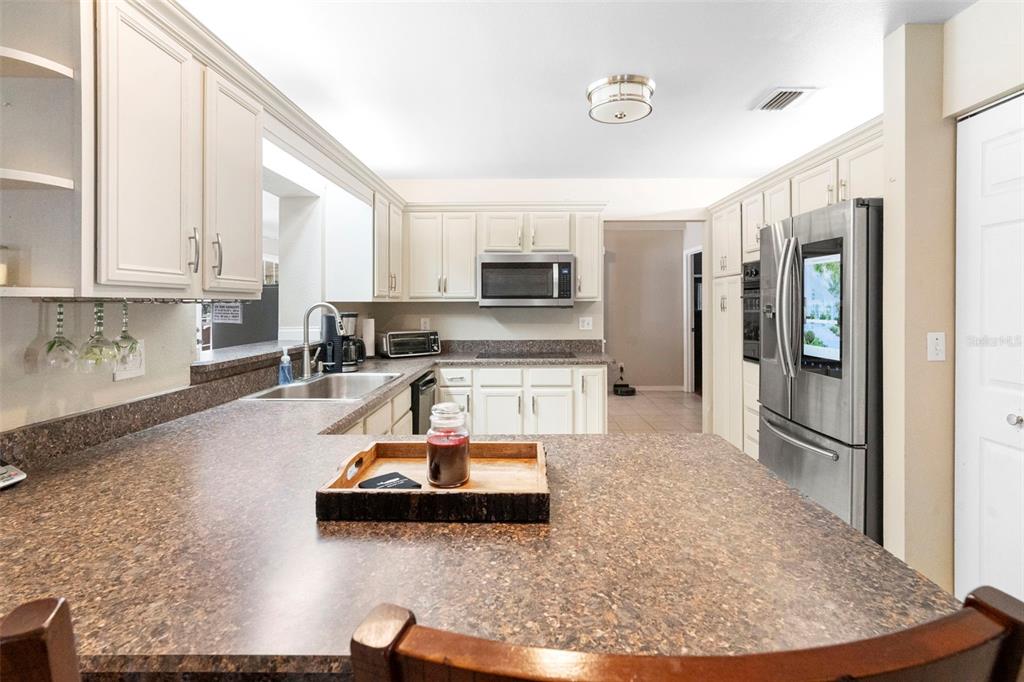 3080 Ragis Road Edgewater, FL 32132 - Photo 39 of 86 a kitchen with stainless steel appliances granite countertop a sink stove and refrigerator