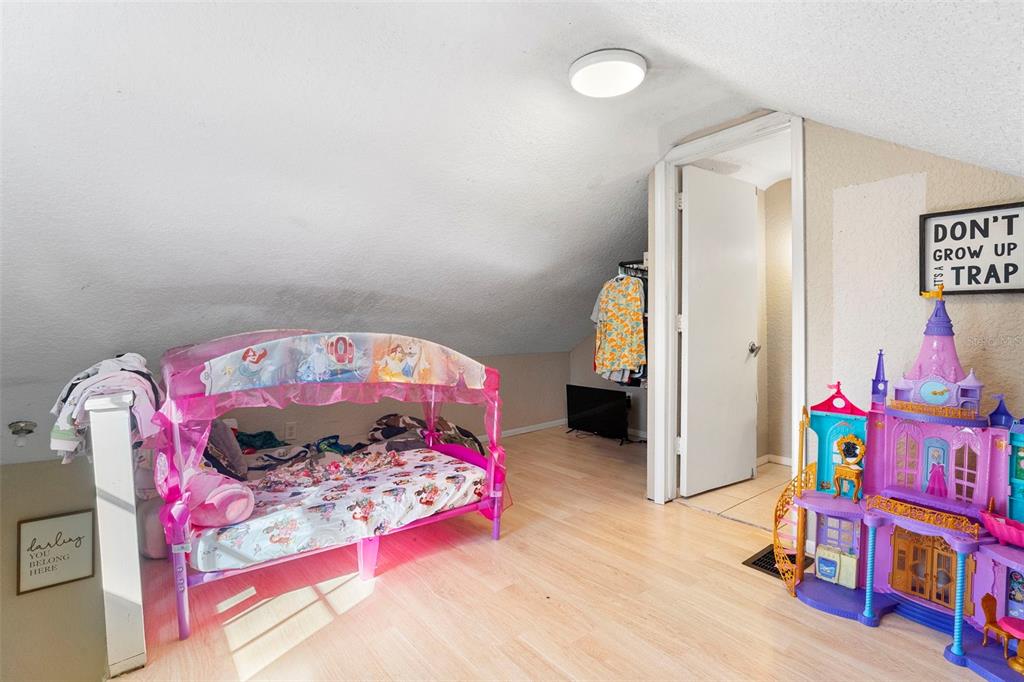 3080 Ragis Road Edgewater, FL 32132 - Photo 77 of 86 a bedroom with a bed and a wooden floor