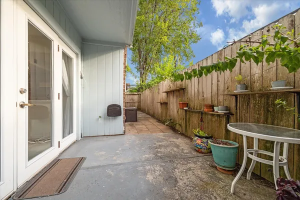 a view of a backyard with chairs and potted plants