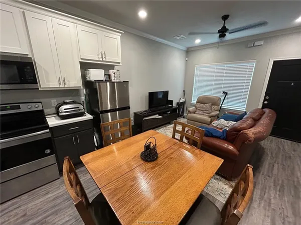 a kitchen with stainless steel appliances granite countertop sink stove refrigerator and wooden floor