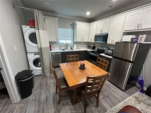 a kitchen with stainless steel appliances granite countertop sink stove refrigerator and wooden floor