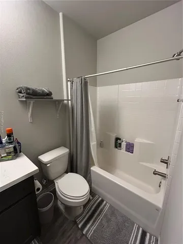 a white toilet sitting next to a bath tub