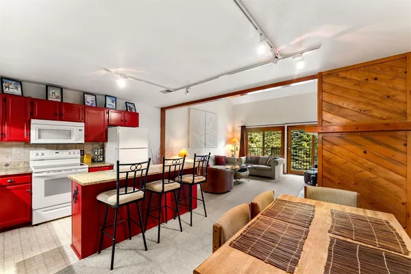 a living room with stainless steel appliances kitchen island granite countertop furniture and a large window