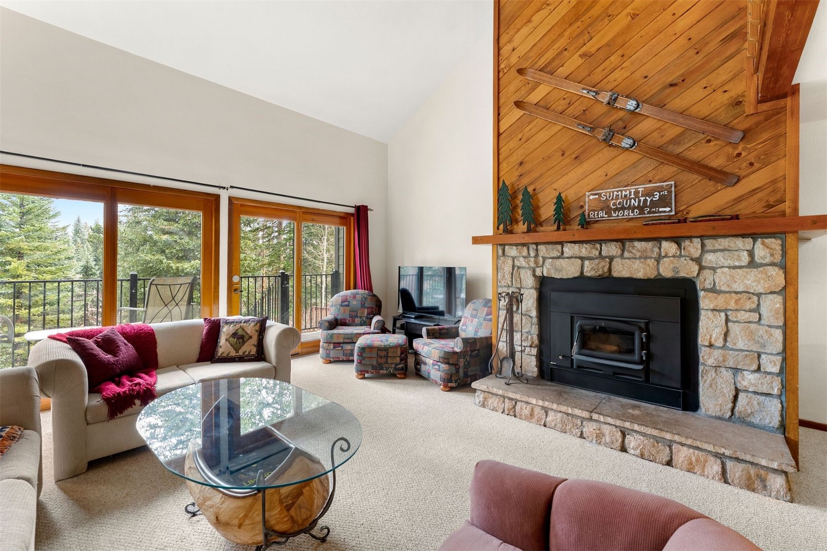 10500 Ryan Gulch Road, Unit J106 Silverthorne, CO 80498 - Photo 2 of 22 a living room with furniture a fireplace and a floor to ceiling window