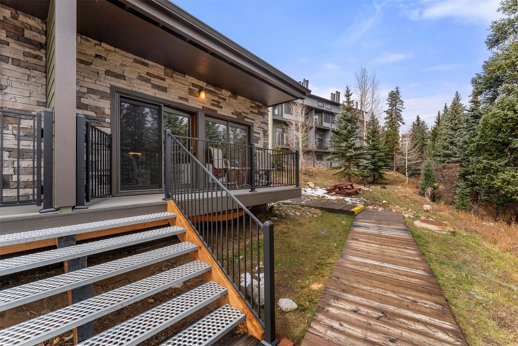10500 Ryan Gulch Road, Unit J106 Silverthorne, CO 80498 - Photo 4 of 22 a view of a patio with table and chairs with wooden floor and fence