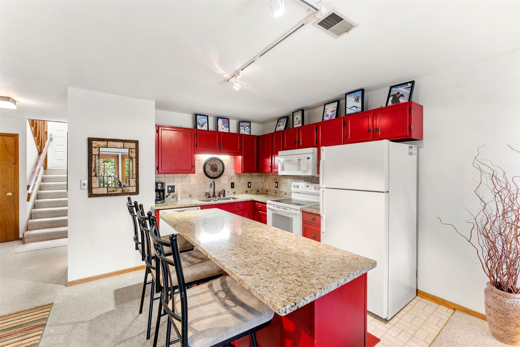 10500 Ryan Gulch Road, Unit J106 Silverthorne, CO 80498 - Photo 6 of 22 a kitchen with stainless steel appliances kitchen island granite countertop a table chairs and a refrigerator