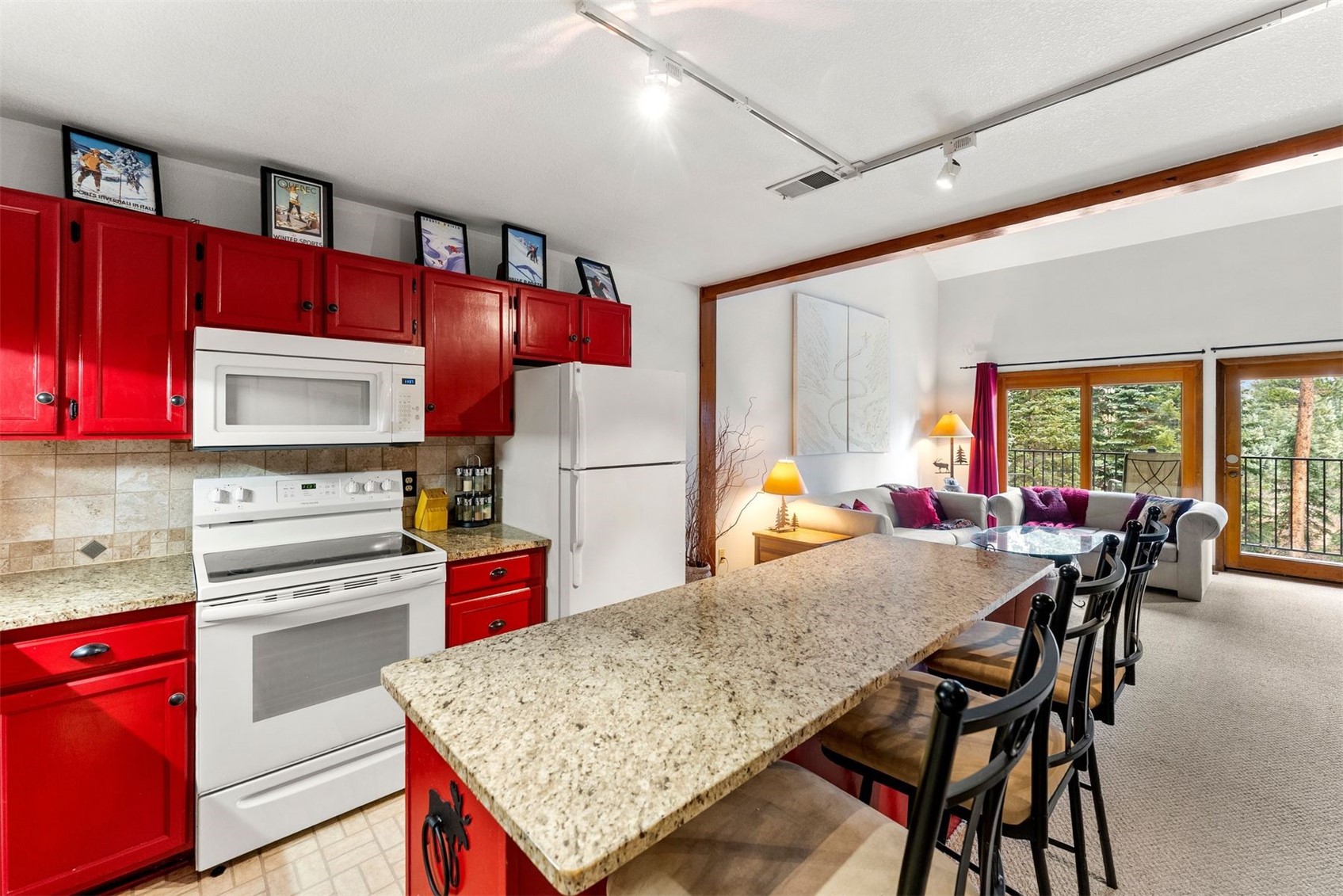 10500 Ryan Gulch Road, Unit J106 Silverthorne, CO 80498 - Photo 9 of 22 a kitchen with stainless steel appliances granite countertop a stove refrigerator sink dining table and chairs