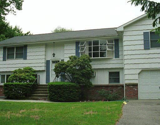 166 Cedar Heights Road Stamford, CT 06905 - Photo 1 of 1 a front view of a house with a yard and garage