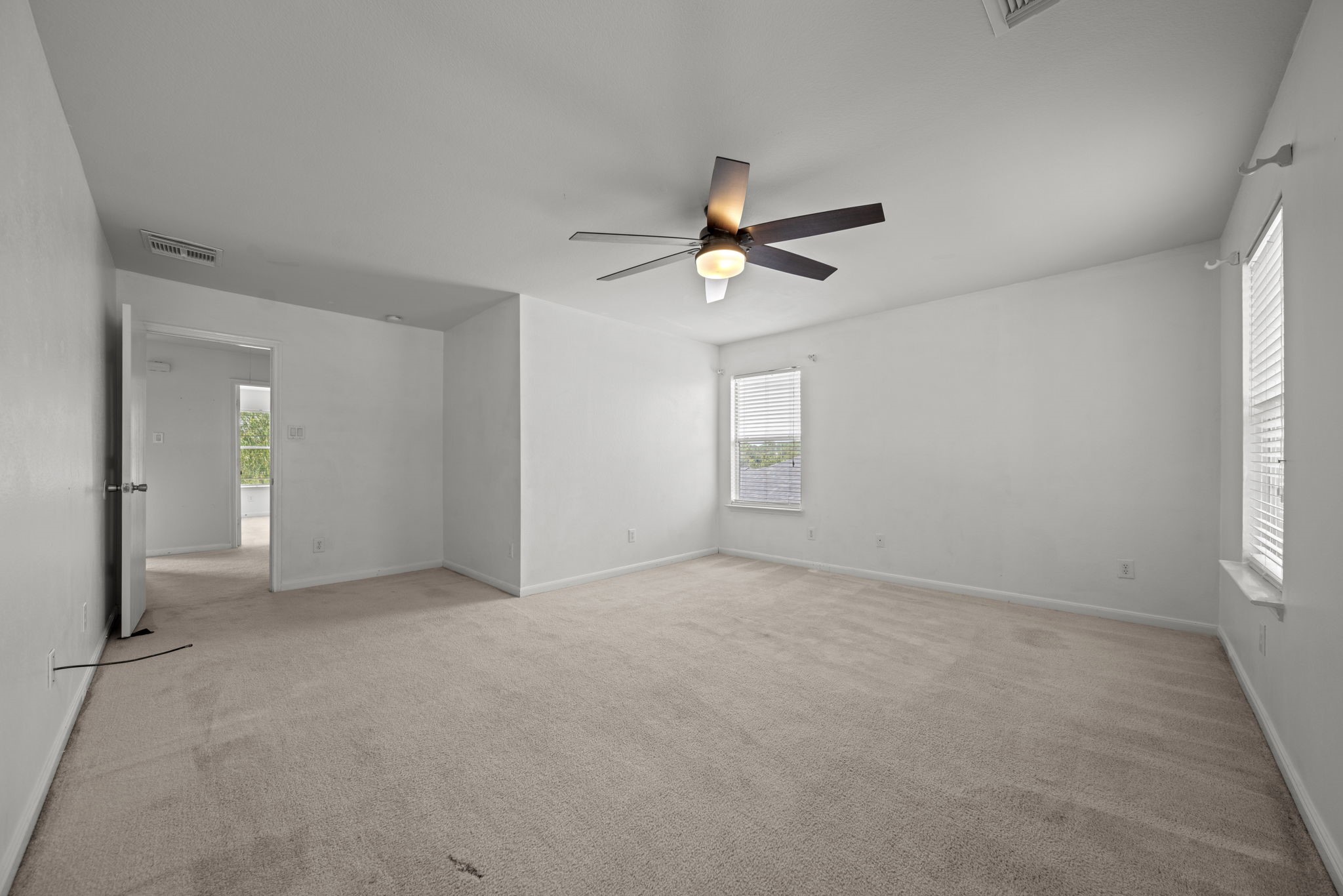 6323 Channelbrook Lane Spring, TX 77379 - Photo 18 of 24 an empty room with windows and a chandelier fan