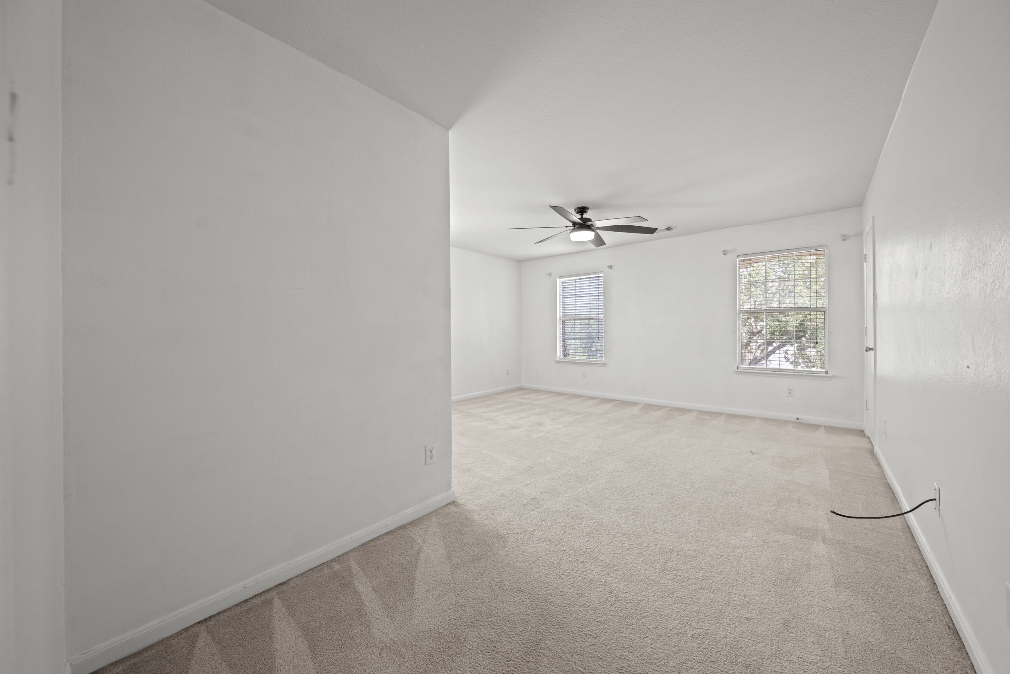 6323 Channelbrook Lane Spring, TX 77379 - Photo 19 of 24 an empty room with windows and chandelier fan