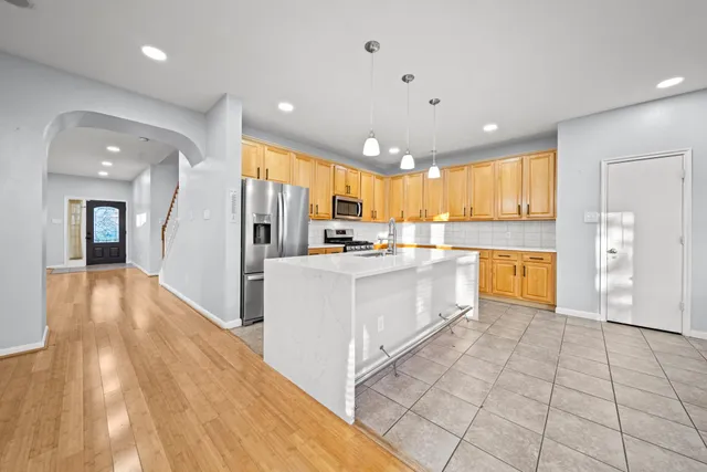 a large white kitchen with a refrigerator a stove and a sink