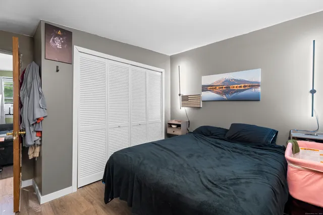 a bedroom with a bed and a painting on the wall