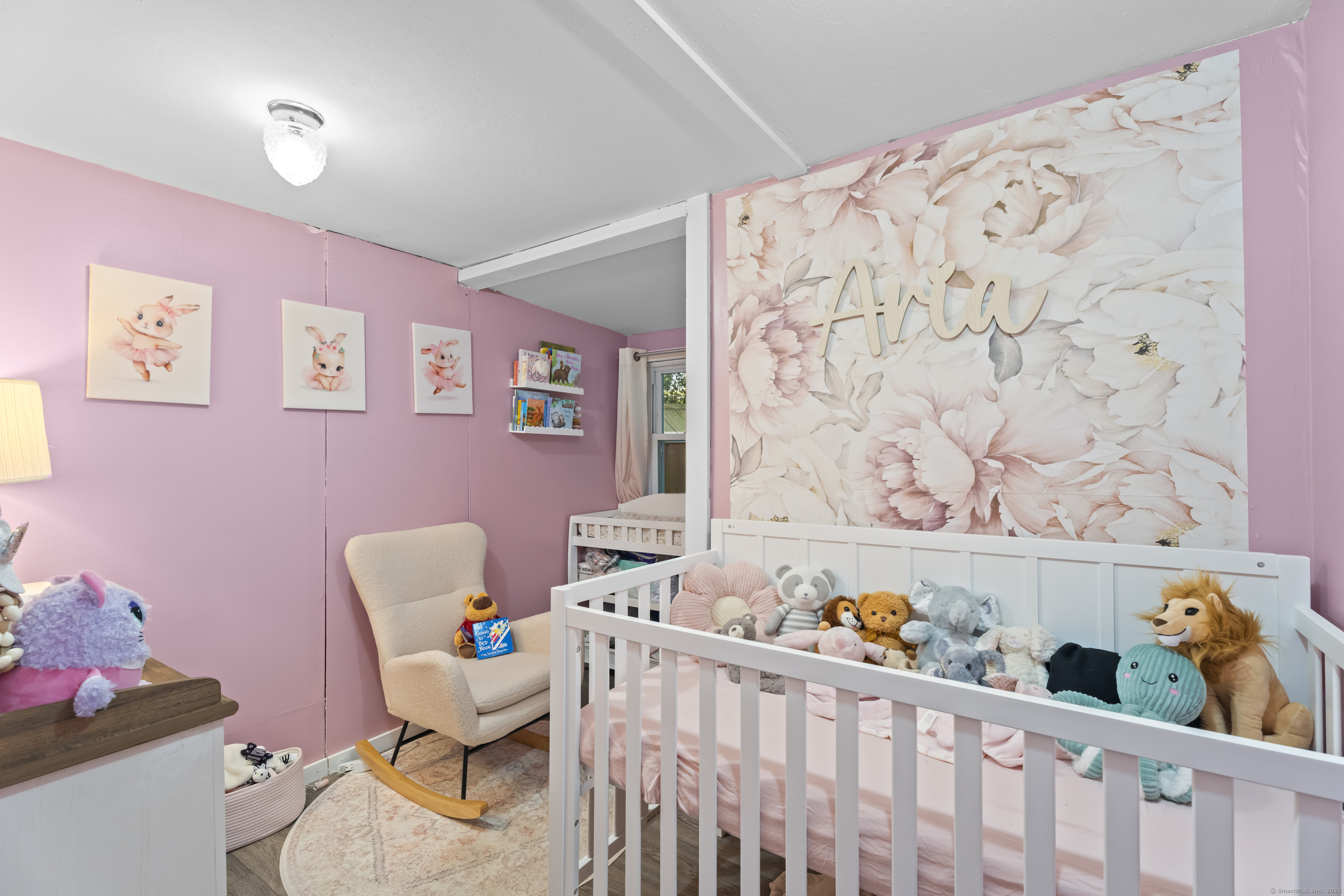 133 West Main Street, Unit MV1 Clinton, CT 06413 - Photo 22 of 36 a living room with a baby crib with couch and a chair