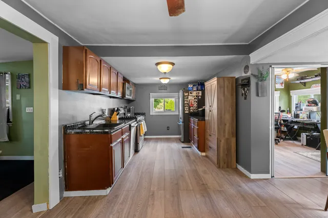 a kitchen with stainless steel appliances granite countertop a refrigerator a stove and a wooden floors