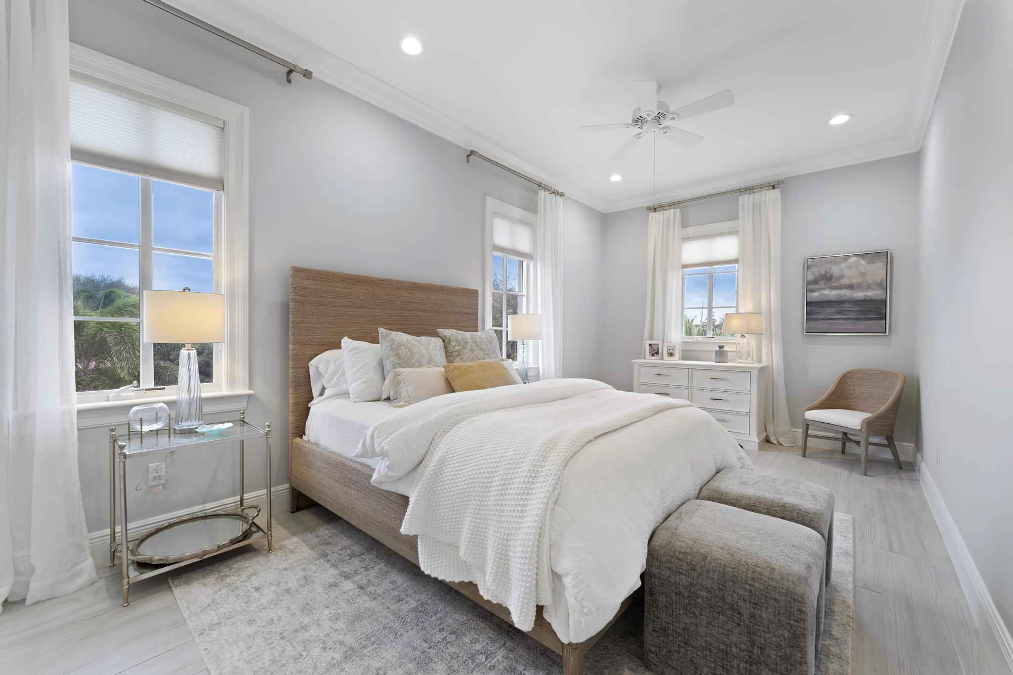 426 Red Hawk Drive Jupiter, FL 33477 - Photo 29 of 70 a spacious bedroom with a bed a table and large window