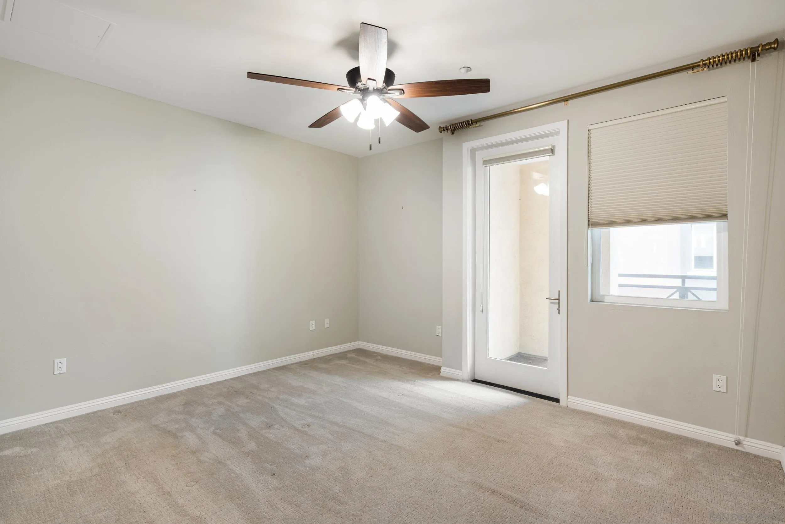 3650 Fifth Avenue, Unit 415 San Diego, CA 92103 - Photo 13 of 31 an empty room with a chandelier fan and windows