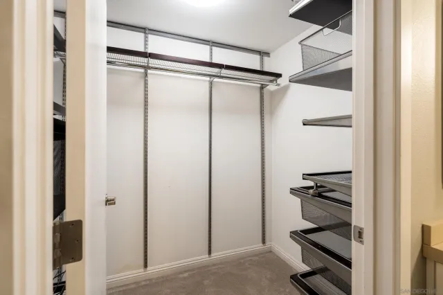 a view of walk in closet with empty racks