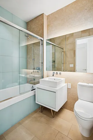 a bedroom with a bed couch and wooden floor